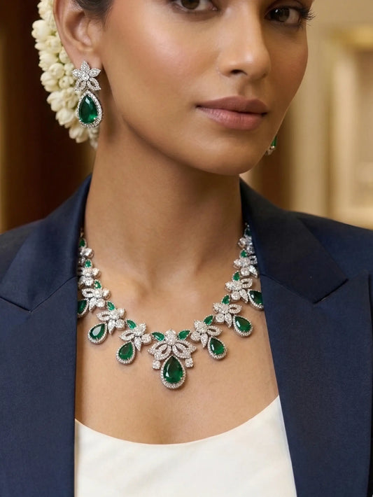 Woman wearing a green and white gemstone necklace and earrings.