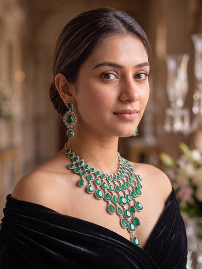 Woman wearing a green emerald necklace and earrings in an elegant setting