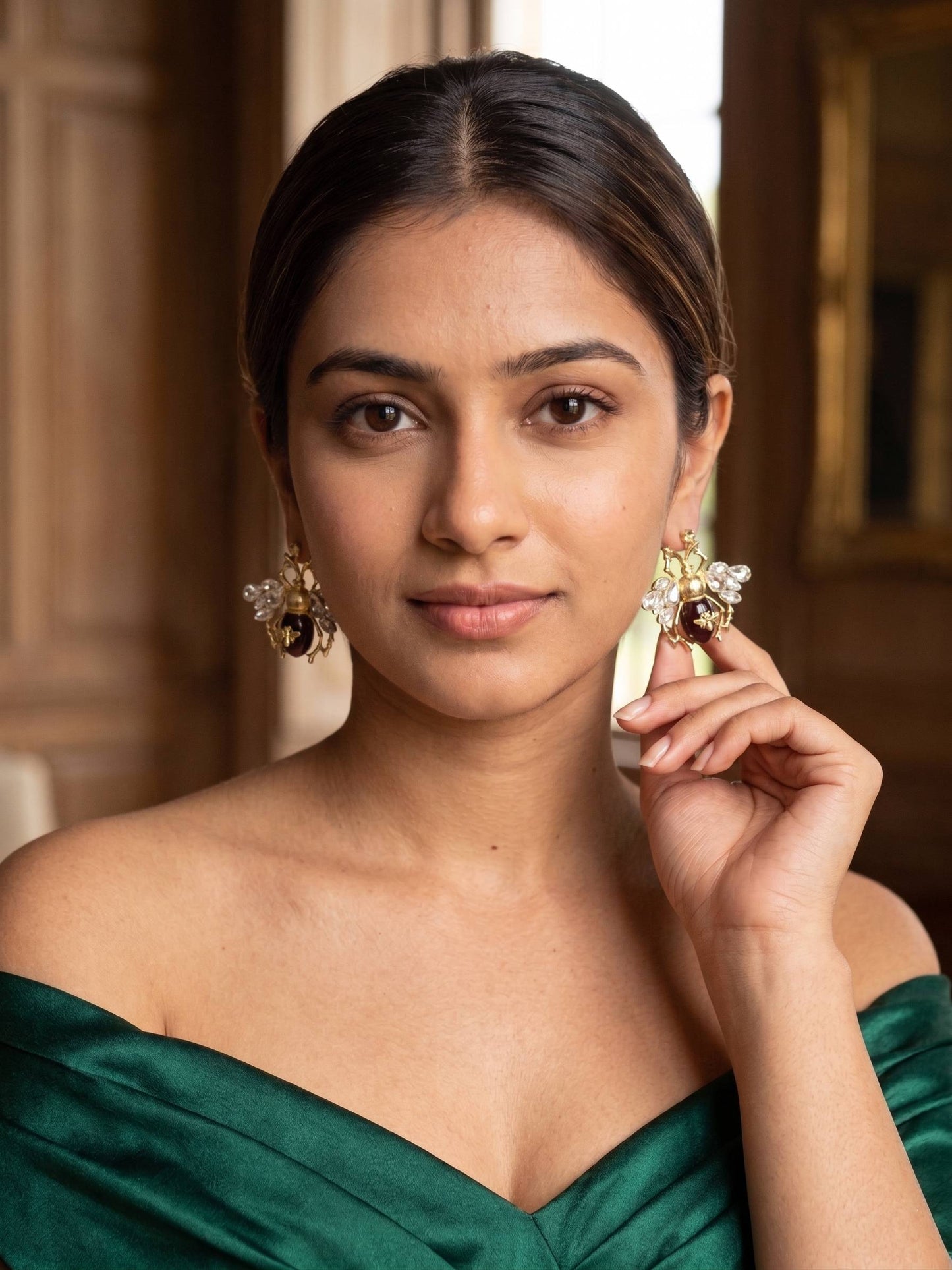 Woman wearing gold earrings in a warm-toned interior setting