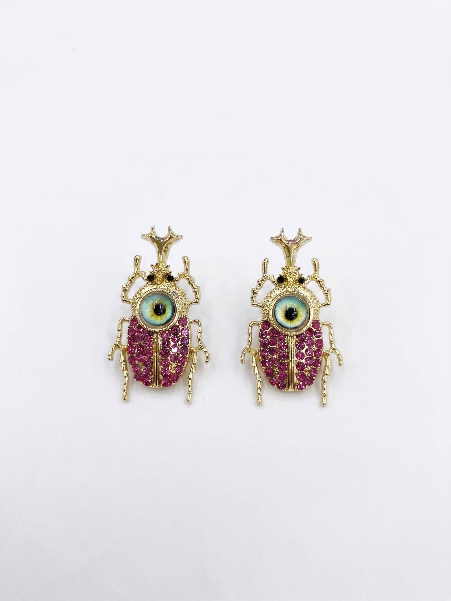 Pair of beetle-shaped earrings with gemstones on a white background
