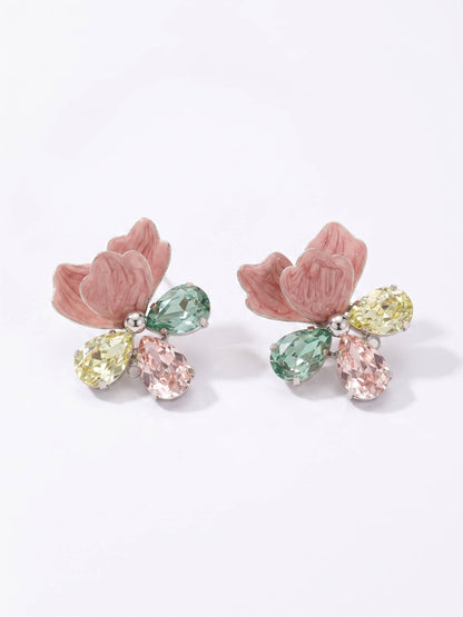 Pair of earrings with pink floral designs and multicolored gemstones on a white background