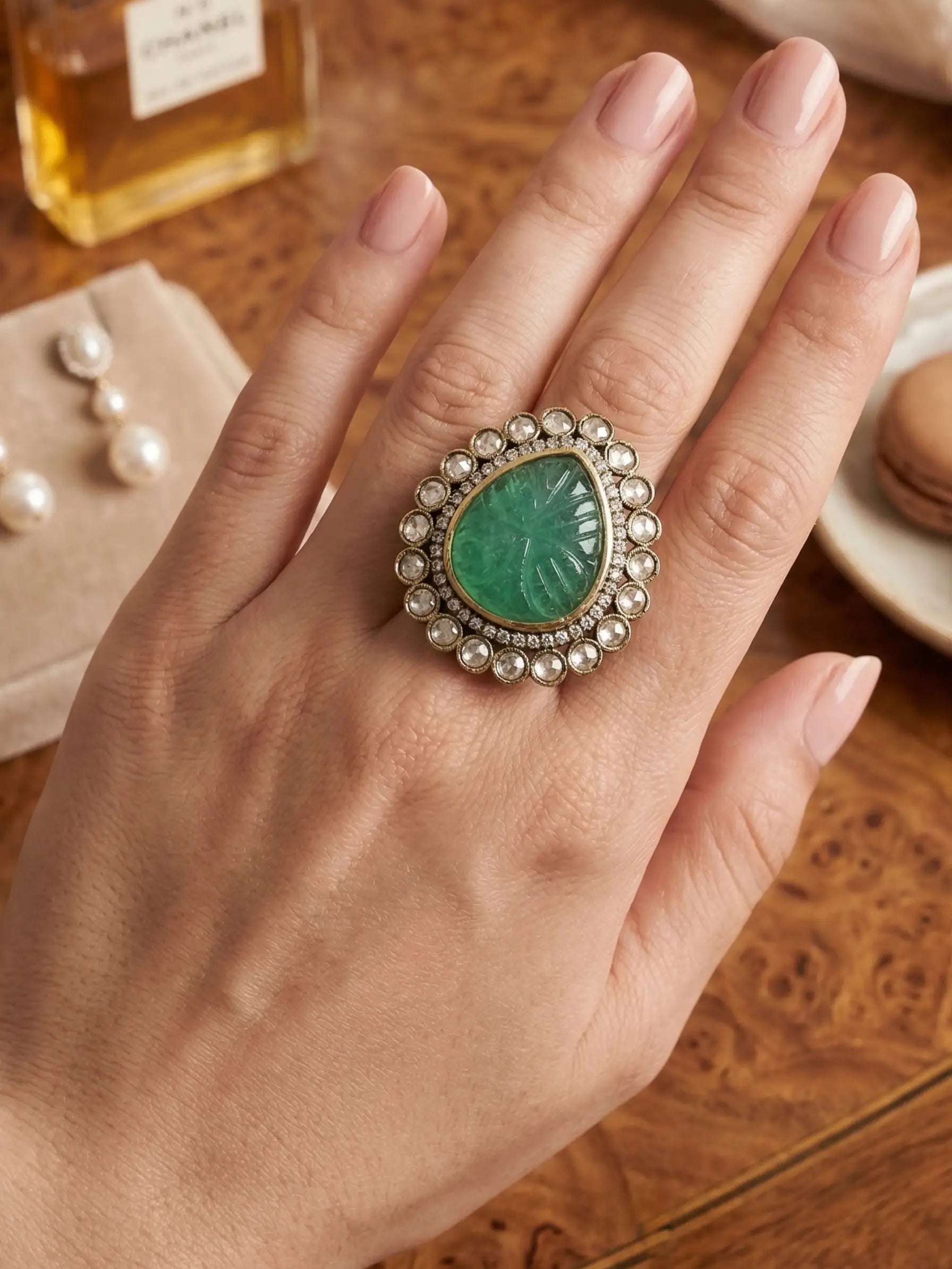 Close-up of teardrop shape green stone ring in Polki setting.