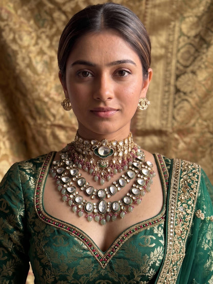 Woman wearing traditional jewelry and a green outfit against a gold textured background