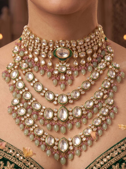 Close-up of a person wearing an elaborate necklace with green and gold accents.