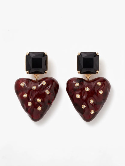 Heart-shaped earrings with black and gold accents on a white background