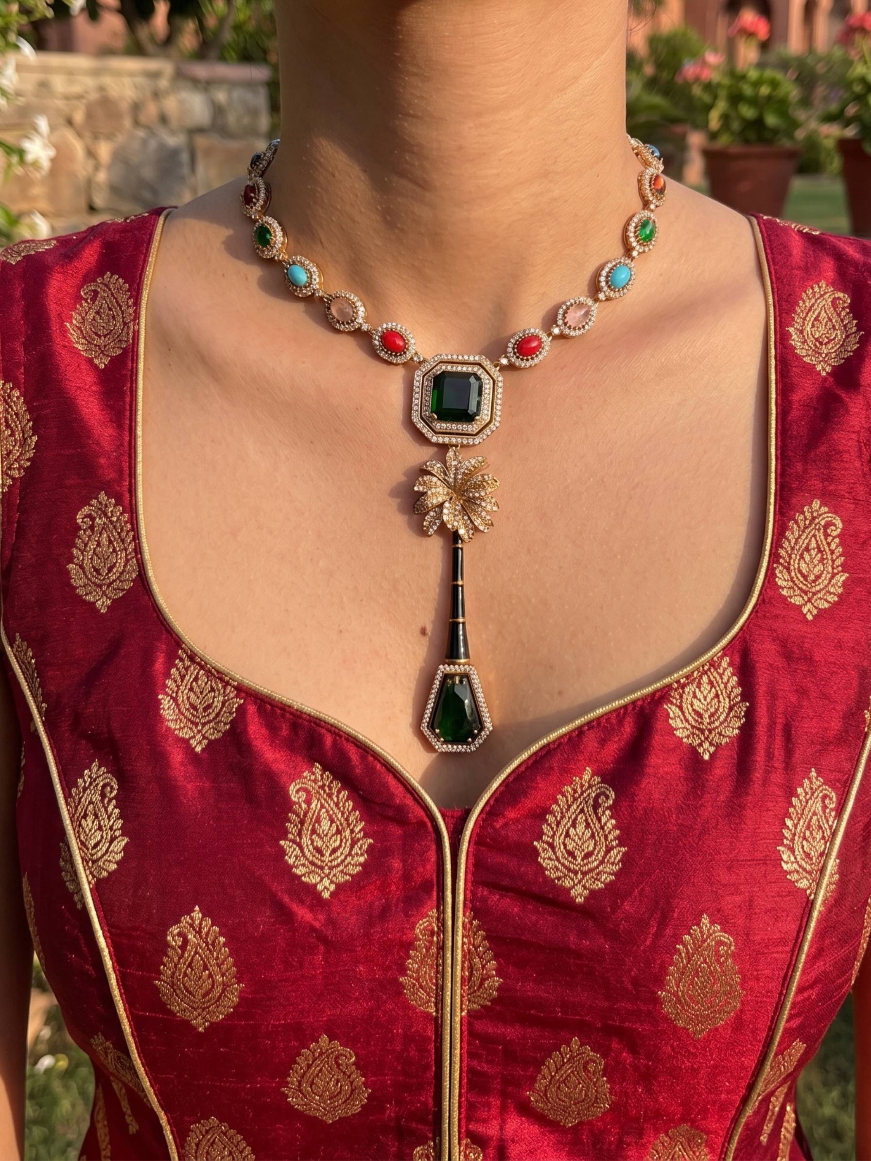 Red embroidered garment with a detailed necklace on a blurred outdoor background