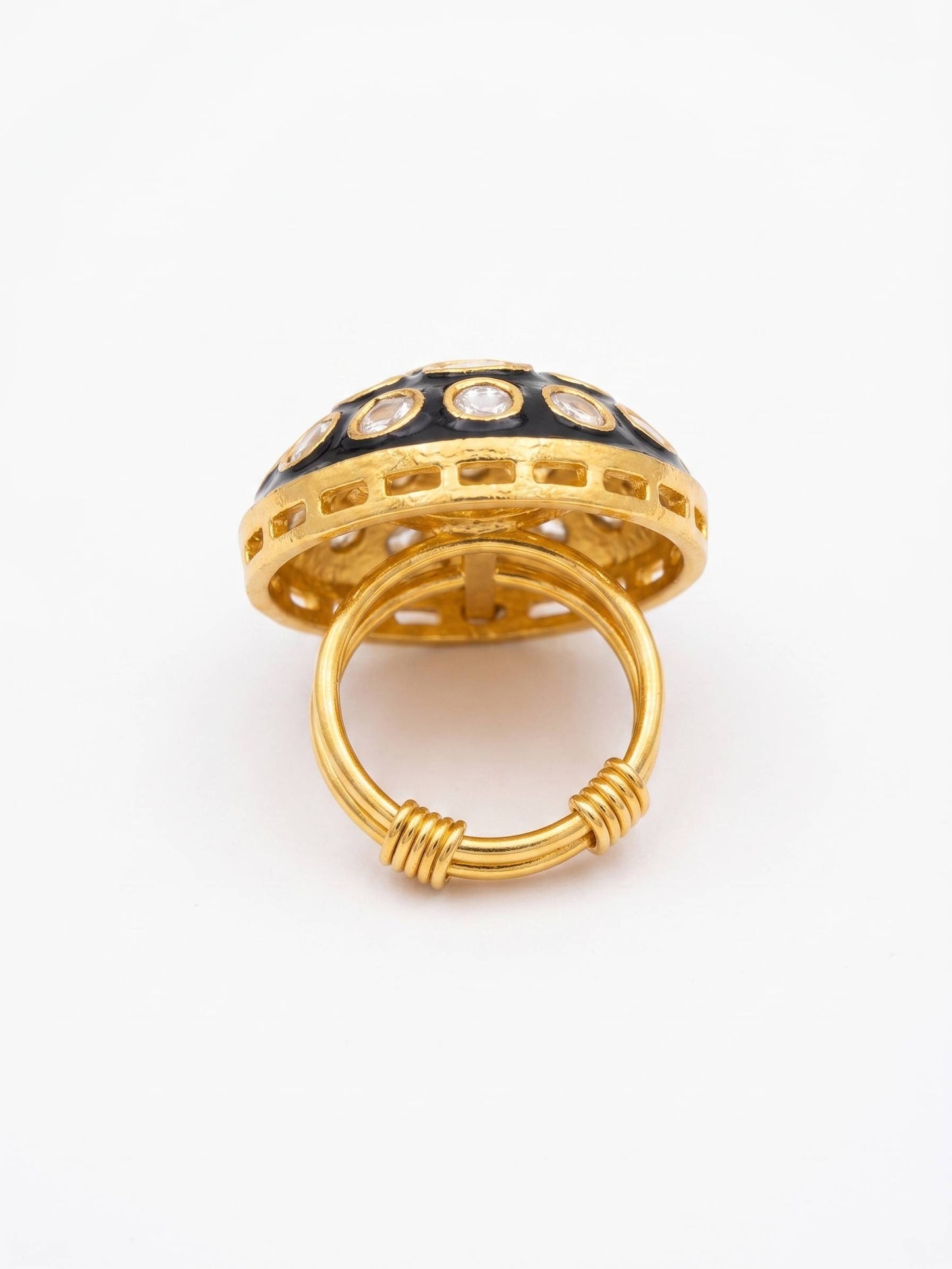 Gold ring with black and white gemstones on a white background