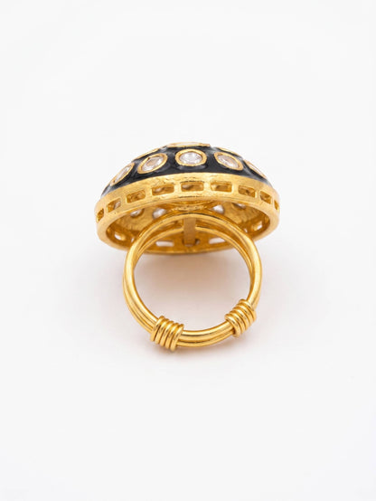 Gold ring with black and white gemstones on a white background
