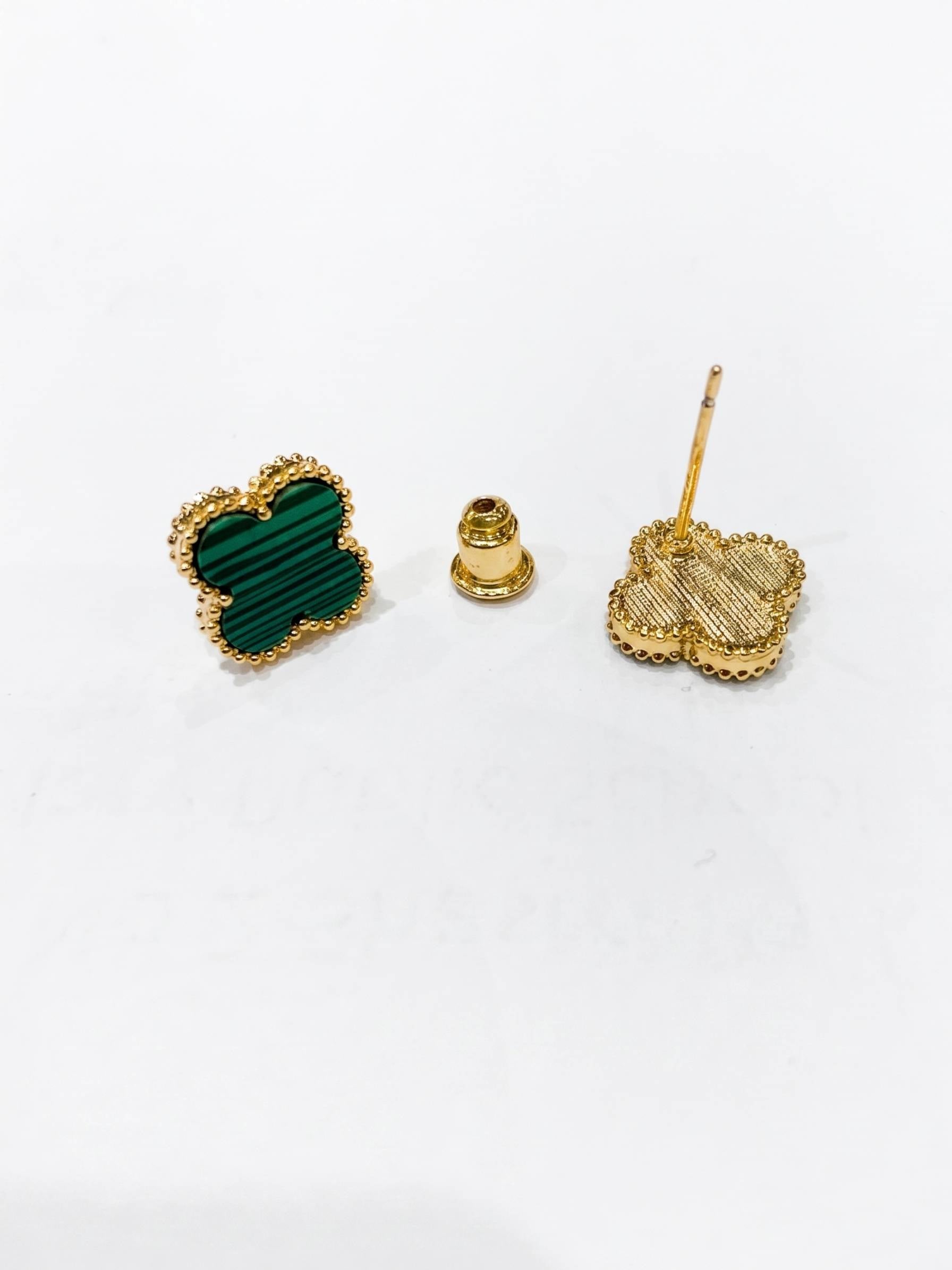 Heart-shaped green stone earrings with gold posts on a white background