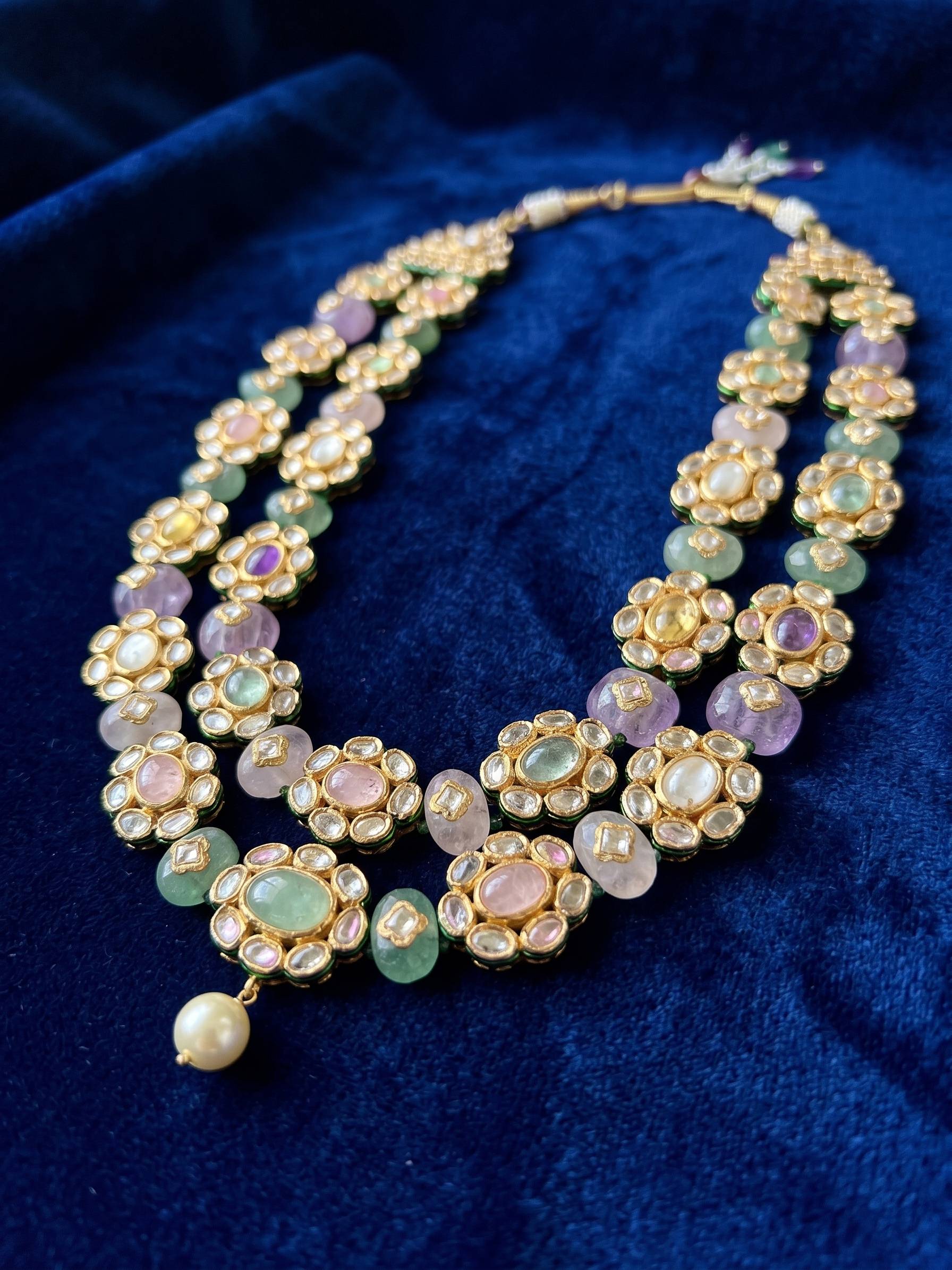 Multicolored beaded necklace on a blue fabric background