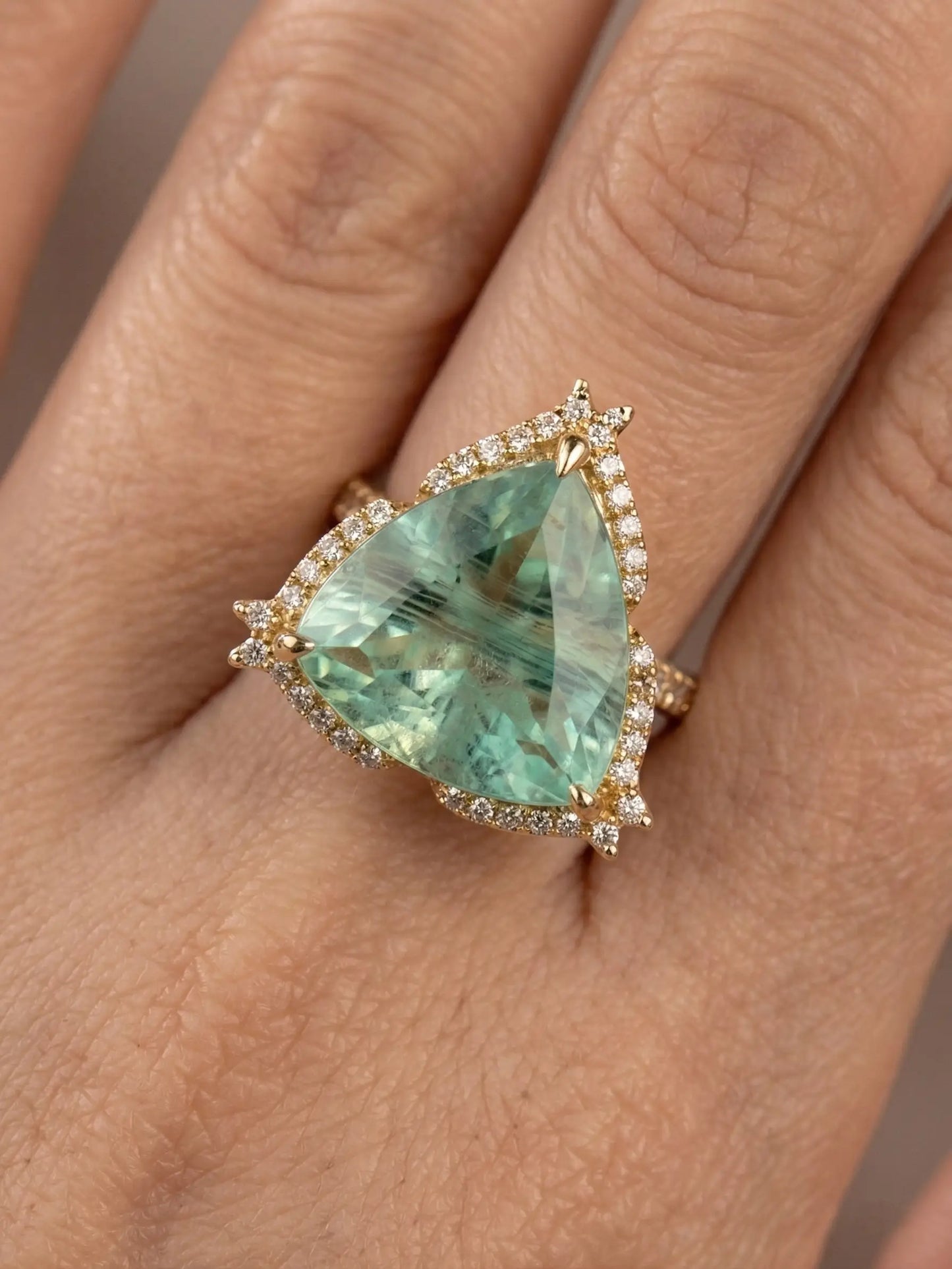 Trillion cut green color stone ring with golden finish