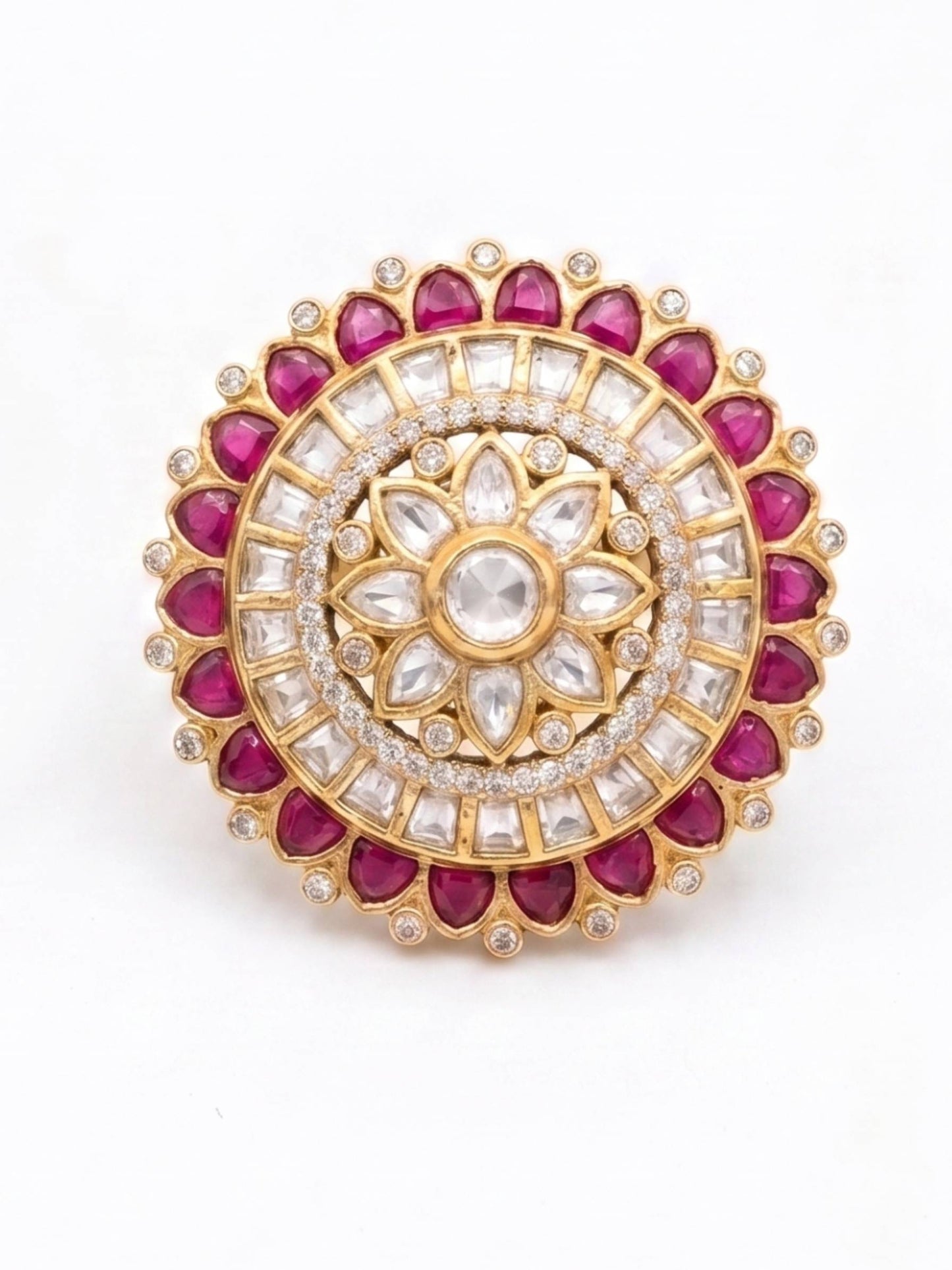 Decorative circular gemstone brooch with red and white stones on a white background