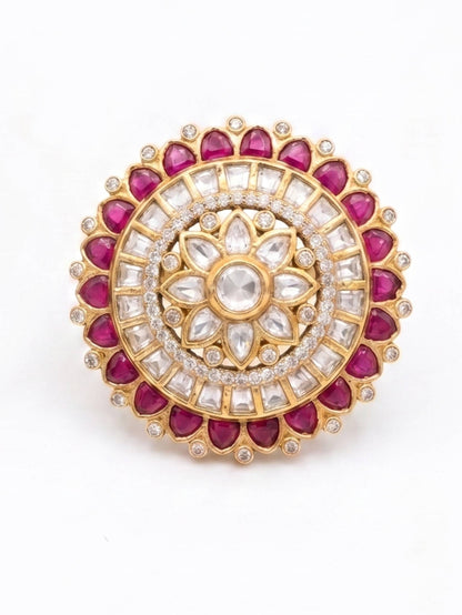 Decorative circular gemstone brooch with red and white stones on a white background
