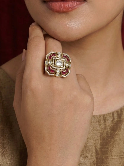 Close-up of a hand wearing an ornate ring with a diamond and ruby stones.