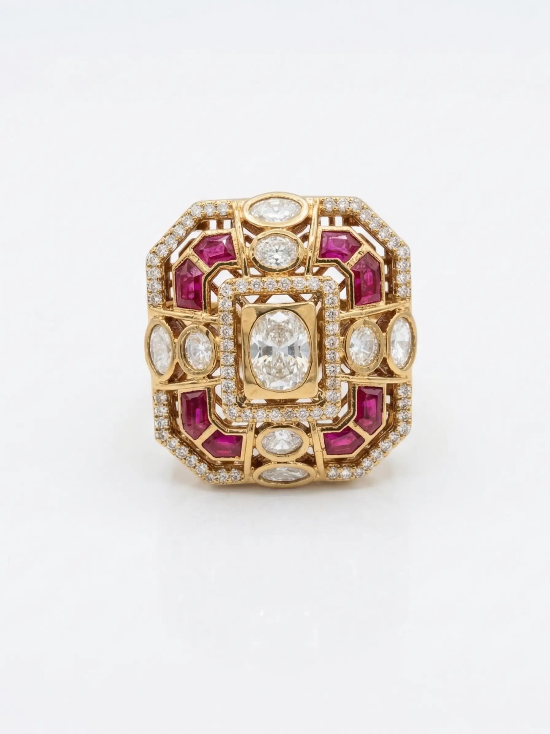 Gold ring with red gemstones and clear stones on a white background