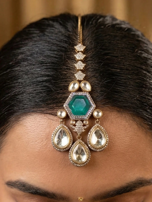 Close-up of a person wearing a decorative hairpiece with green gemstone and gold accents.