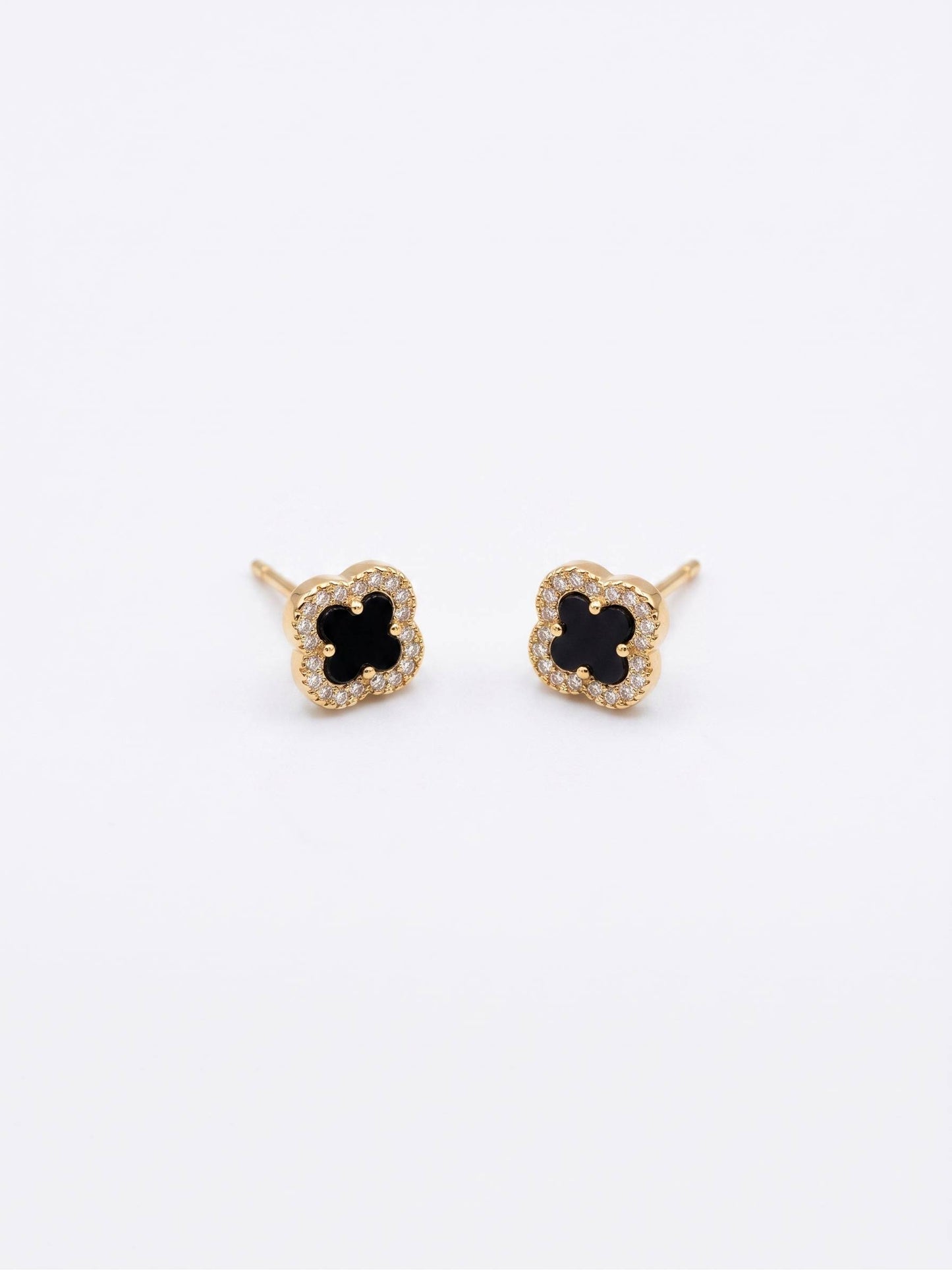 Pair of gold earrings with black center on a white background