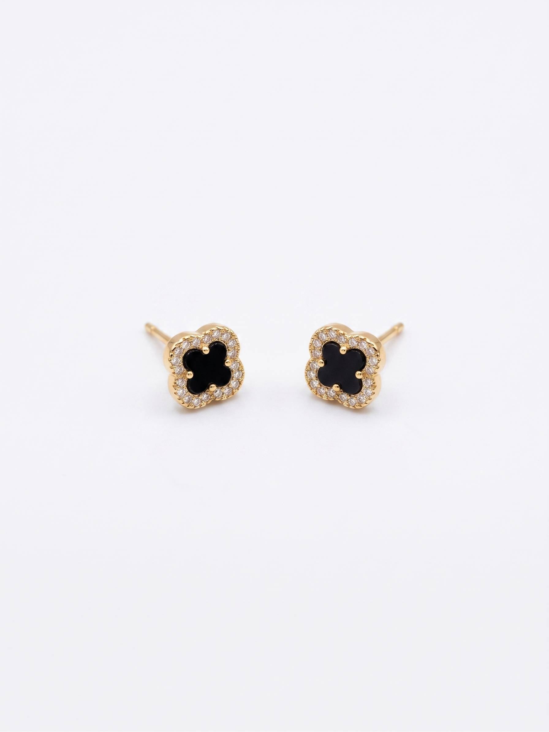 Pair of gold earrings with black center on a white background