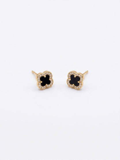 Pair of gold earrings with black center on a white background