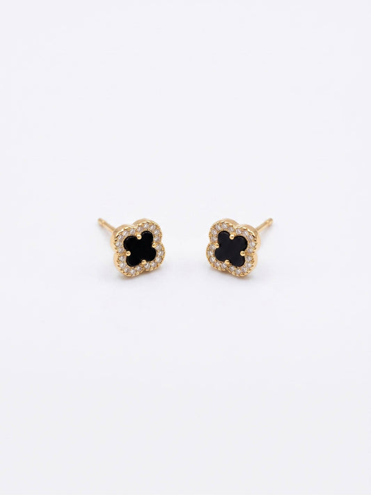 Pair of gold earrings with black center on a white background