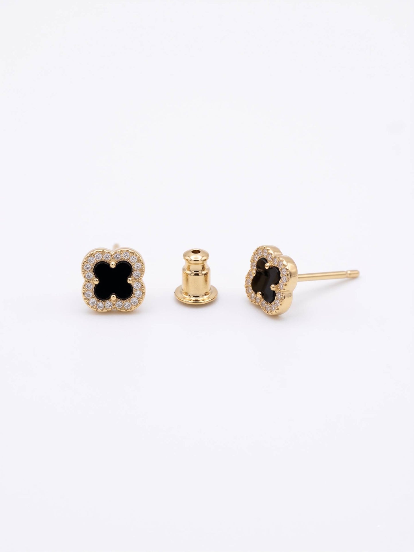 Gold earrings with black gemstones on a white background