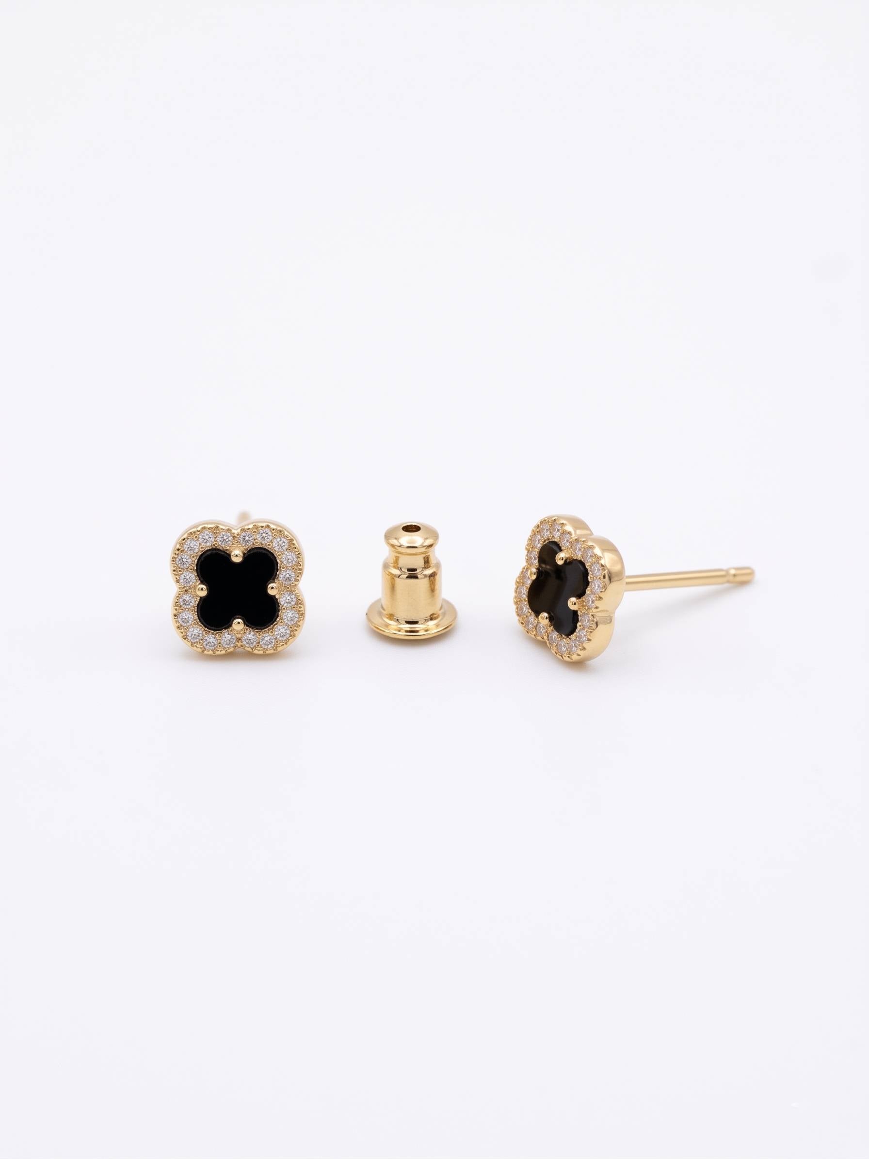 Gold earrings with black gemstones on a white background