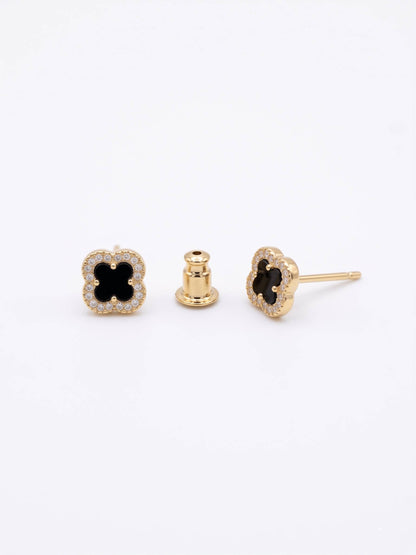Gold earrings with black gemstones on a white background