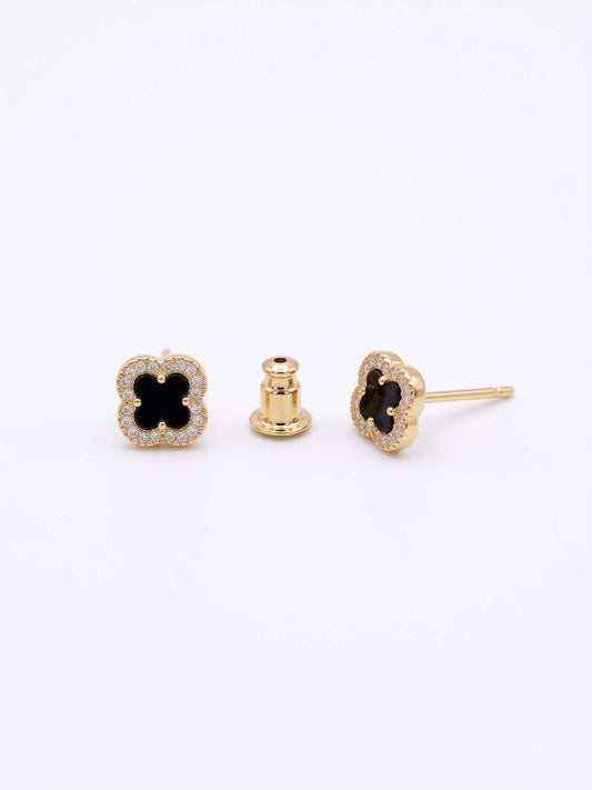 Gold earrings with black gemstones on a white background