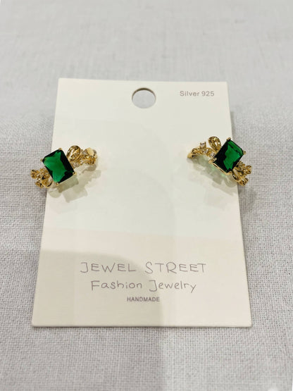 Gold and green earrings on a Jewel Street branded card.