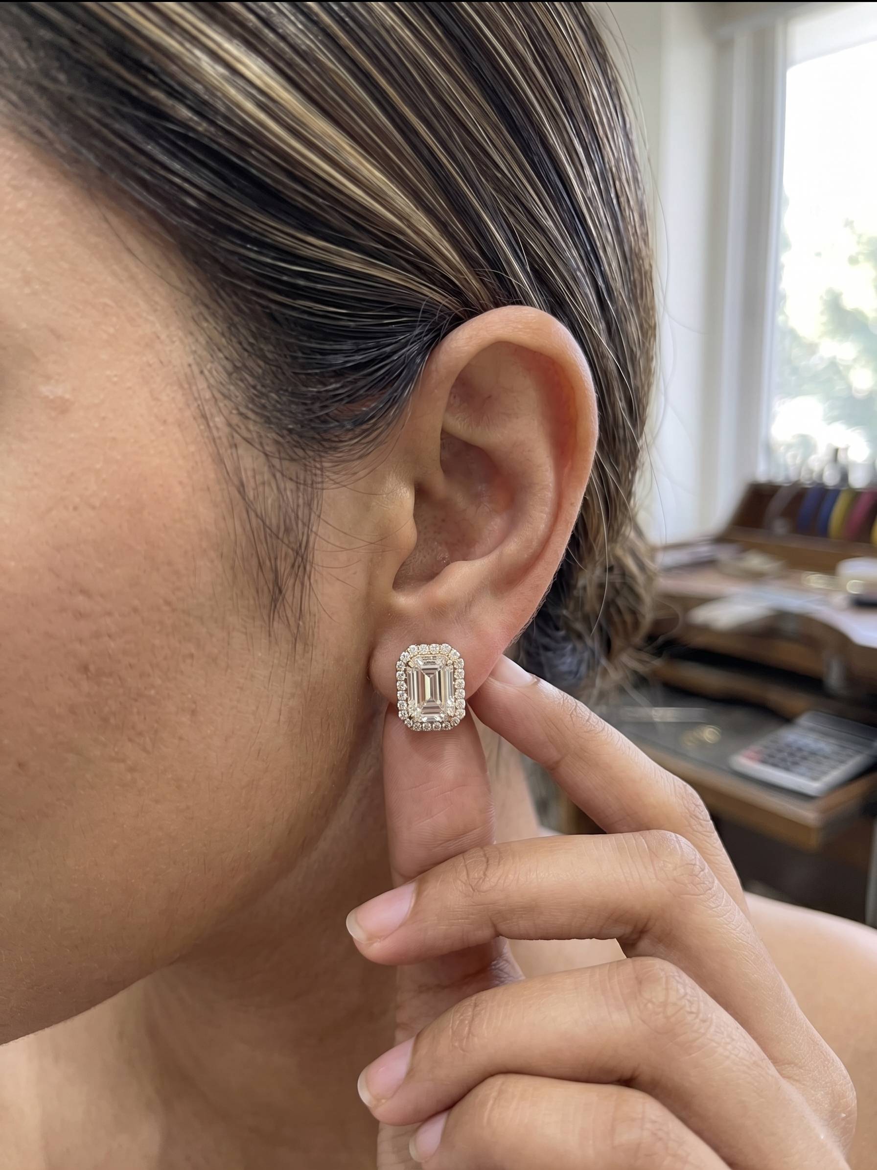 Sophisticated emerald-cut earrings design with a radiant halo setting.