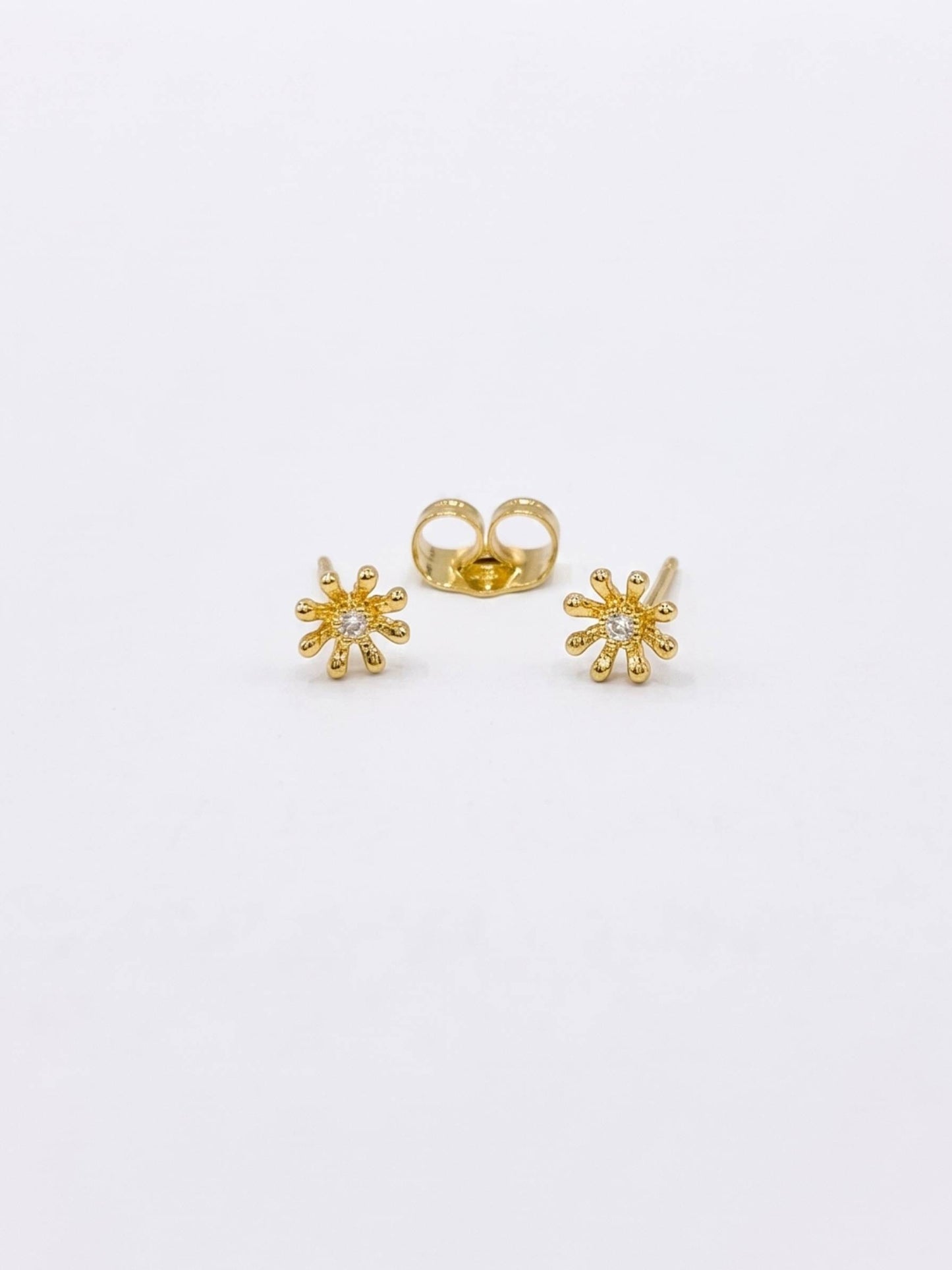 Gold flower-shaped earrings on a white background