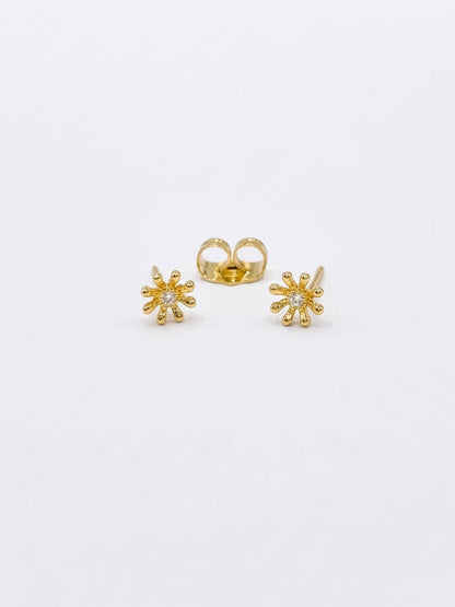 Gold flower-shaped earrings on a white background