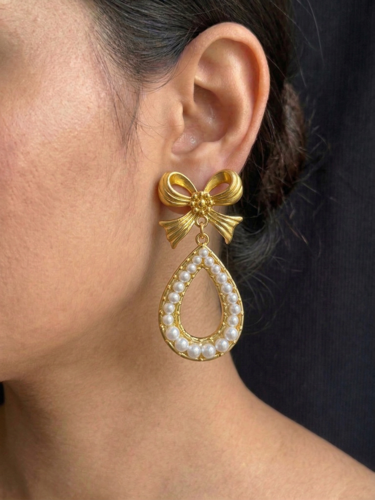 Elegant gold-finish bow earrings with teardrop pearl dangle design for women