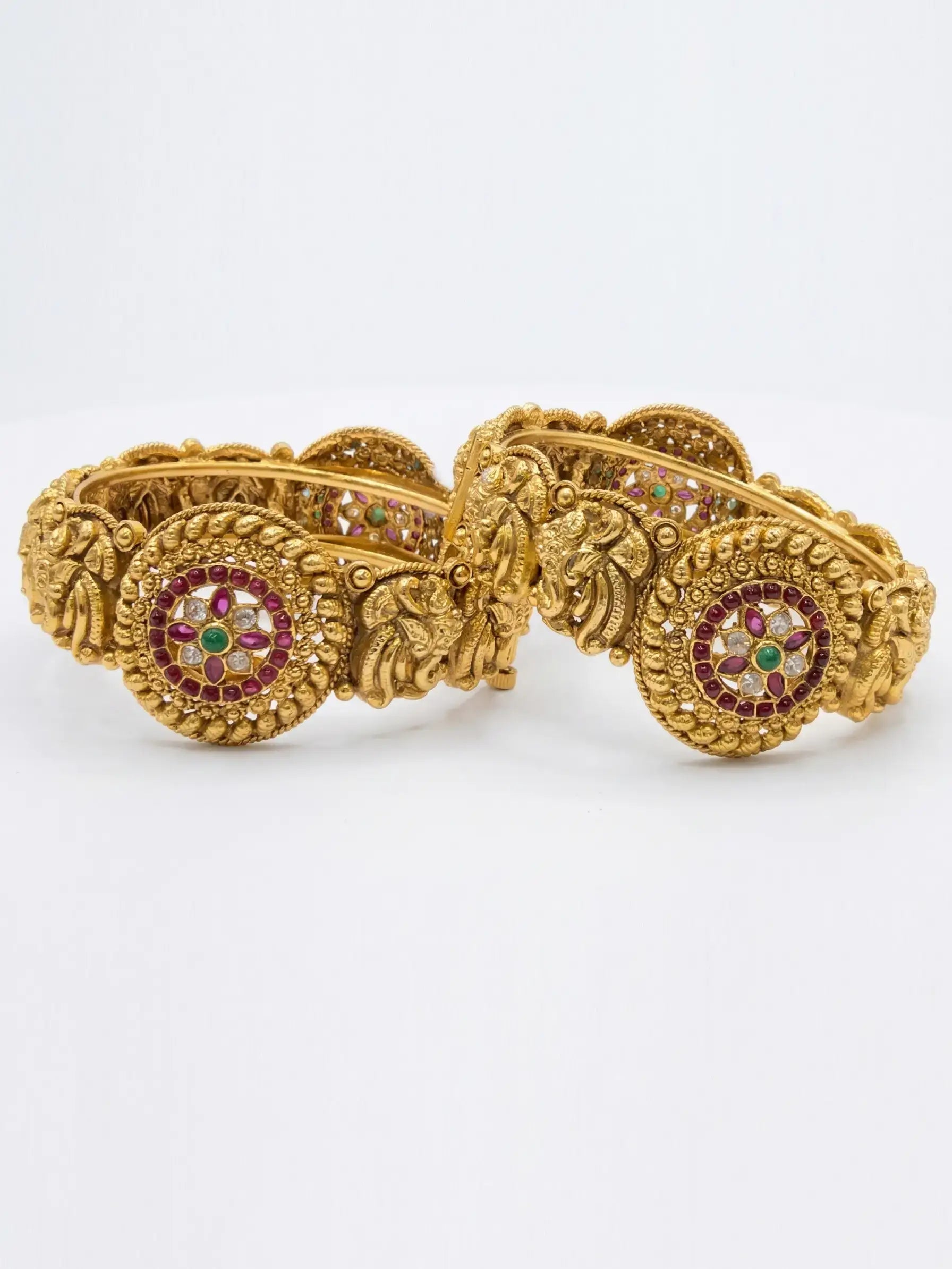 Gold bracelet with gemstone accents on a white background