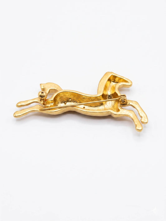 Gold horse-shaped brooch with embedded stones on a white background