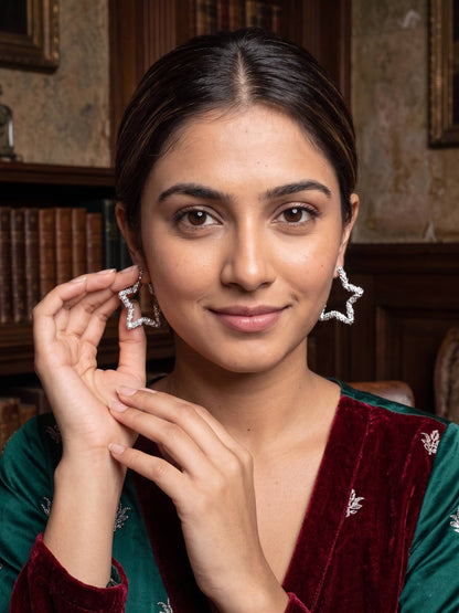 Woman wearing star-shaped earrings in a formal setting