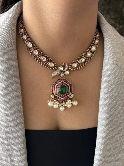 Elegant necklace with gemstones and pearls worn by a person