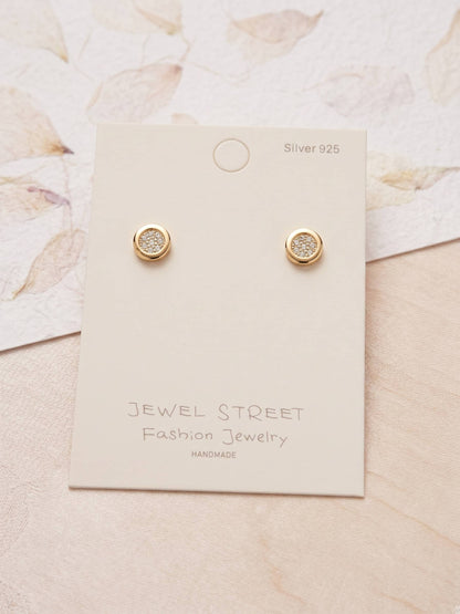 Gold earrings on a Jewel Street branded card with a floral background