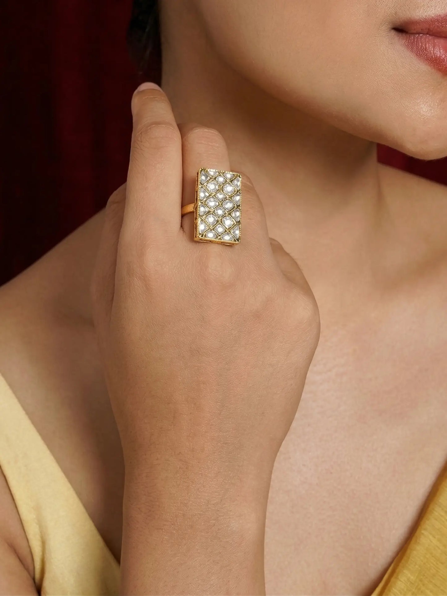 Close-up of a hand wearing a decorative ring with a blurred background