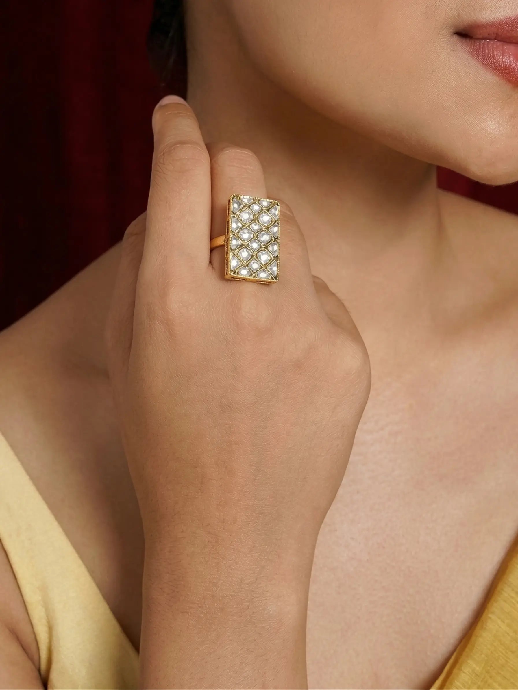 Close-up of a hand wearing a decorative ring with a blurred background
