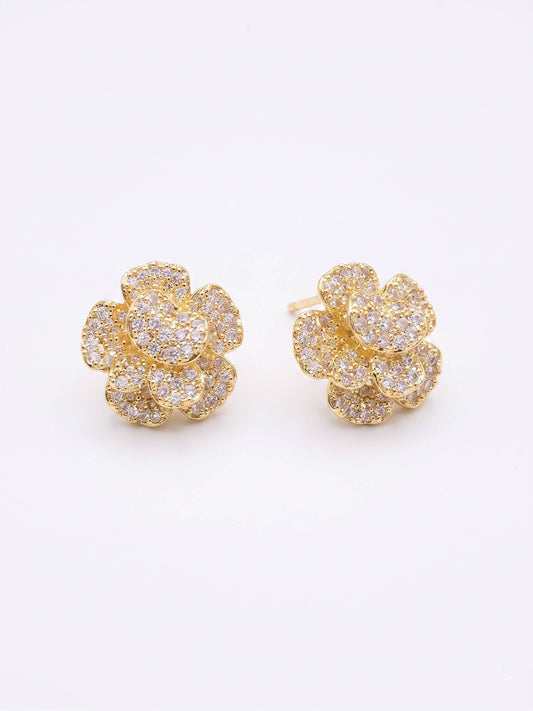 Gold flower-shaped earrings with clear gemstones on a white background