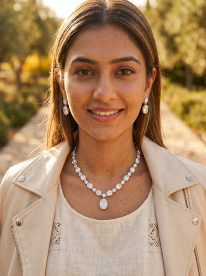Woman wearing a pearl necklace outdoors with a blurred natural background
