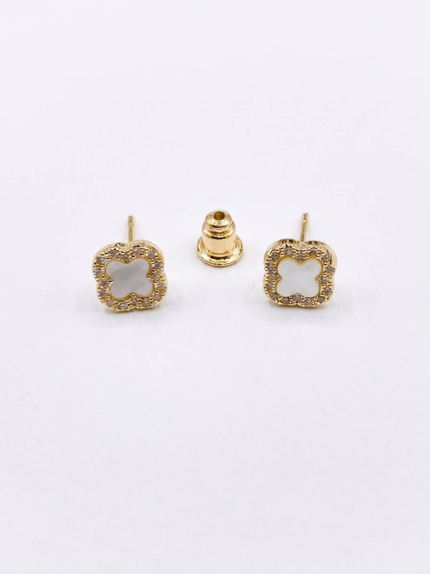 Gold square earrings with a central gemstone on a white background