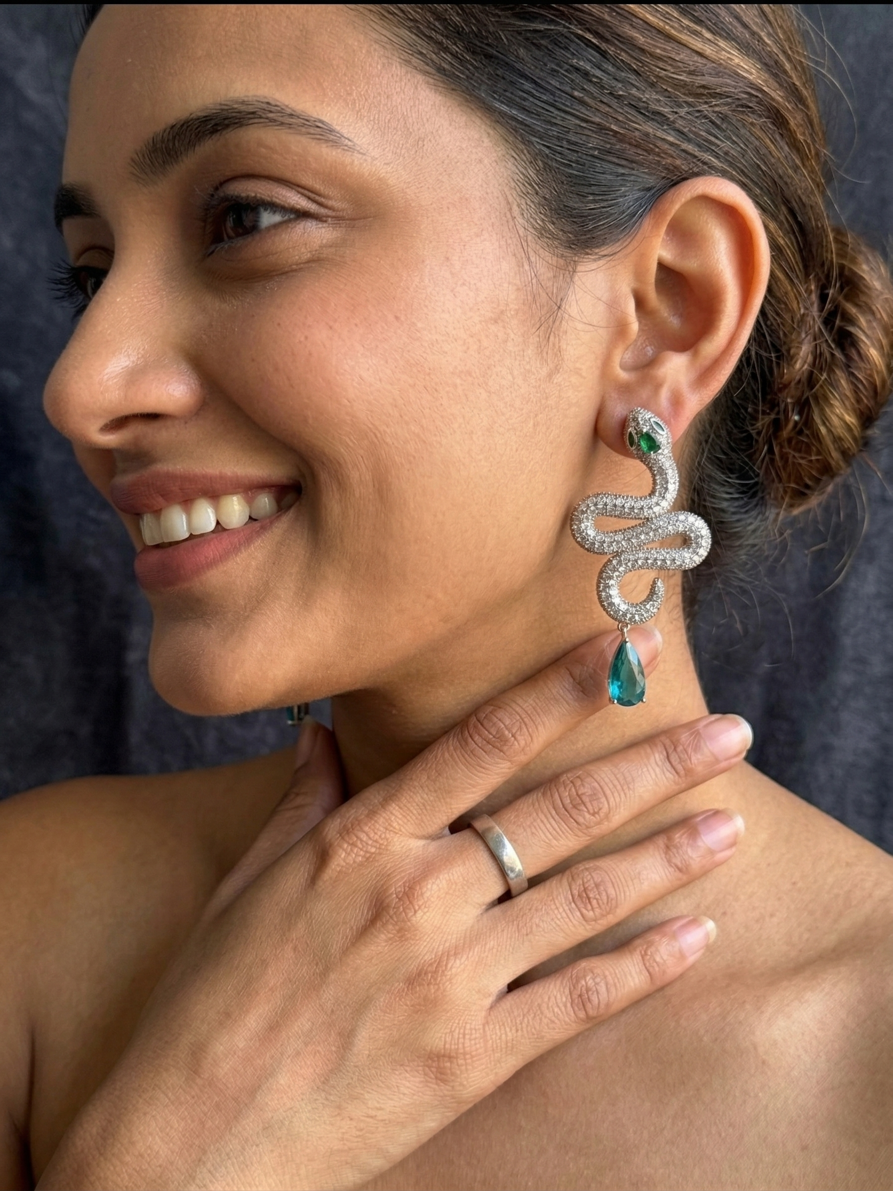 Pair of silver serpentine dangle earrings with aqua teal stones