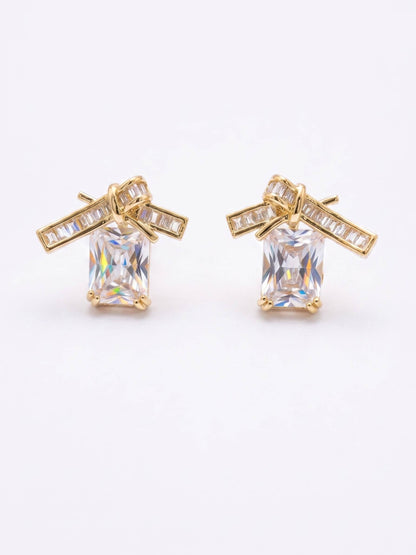 Gold earrings with clear gemstones on a white background