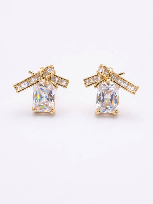 Gold earrings with clear gemstones on a white background
