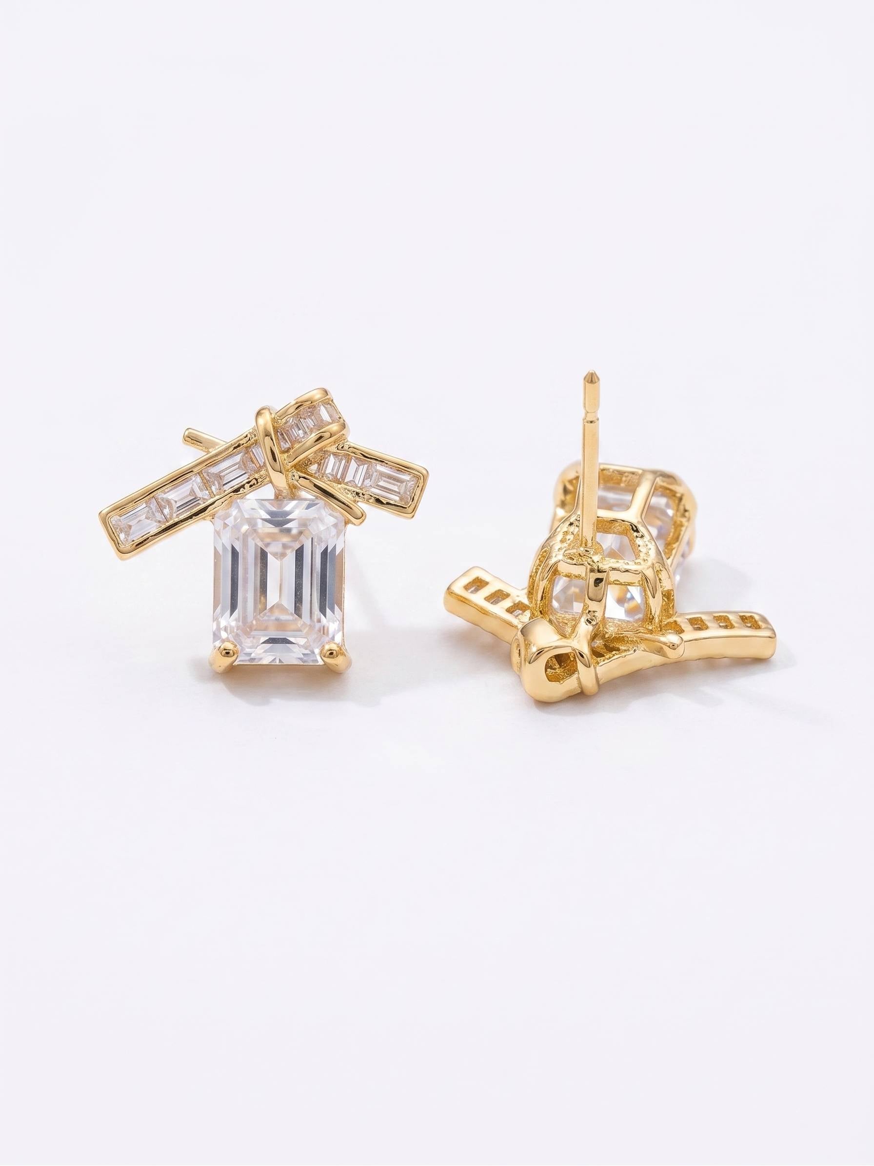 Gold earrings with clear gemstones on a white background