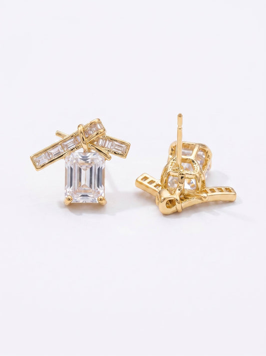 Gold earrings with clear gemstones on a white background