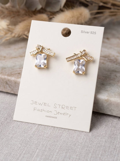 Gold earrings with clear stones on a 'Jewel Street' branded card.