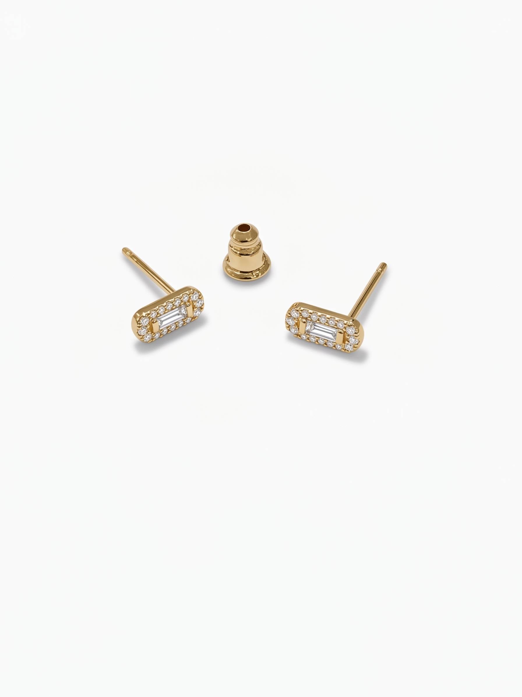 Gold earrings with clear stones on a white background